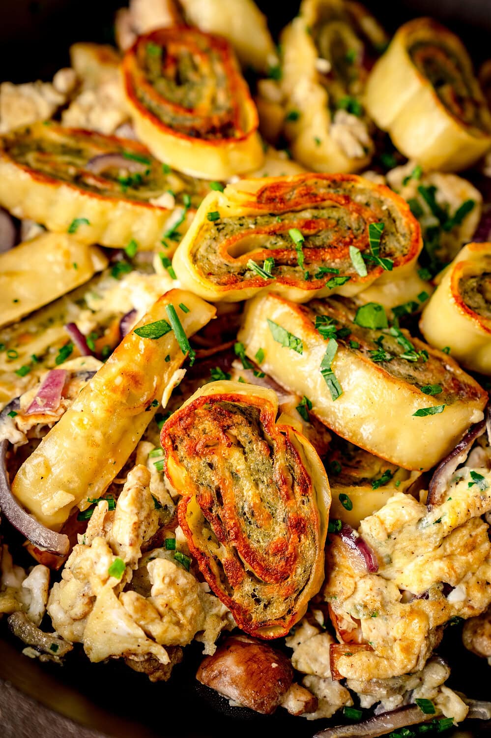 Fried Maultaschen in a pan with onions, egg and herbs