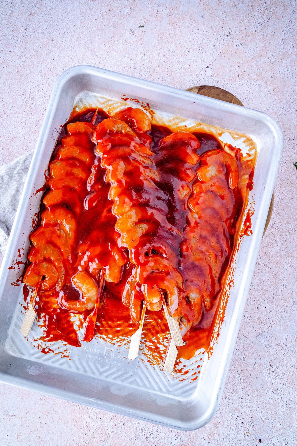 Gochujang shrimp skewers on a tray to marinate