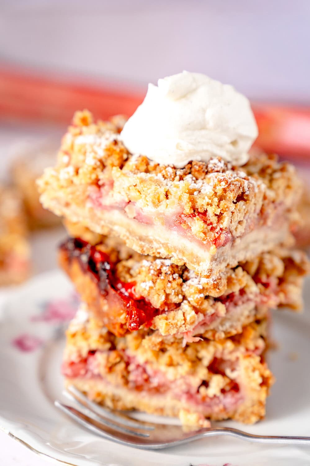 Close-up of stacked rhubarb cake with a dollop of cream on top