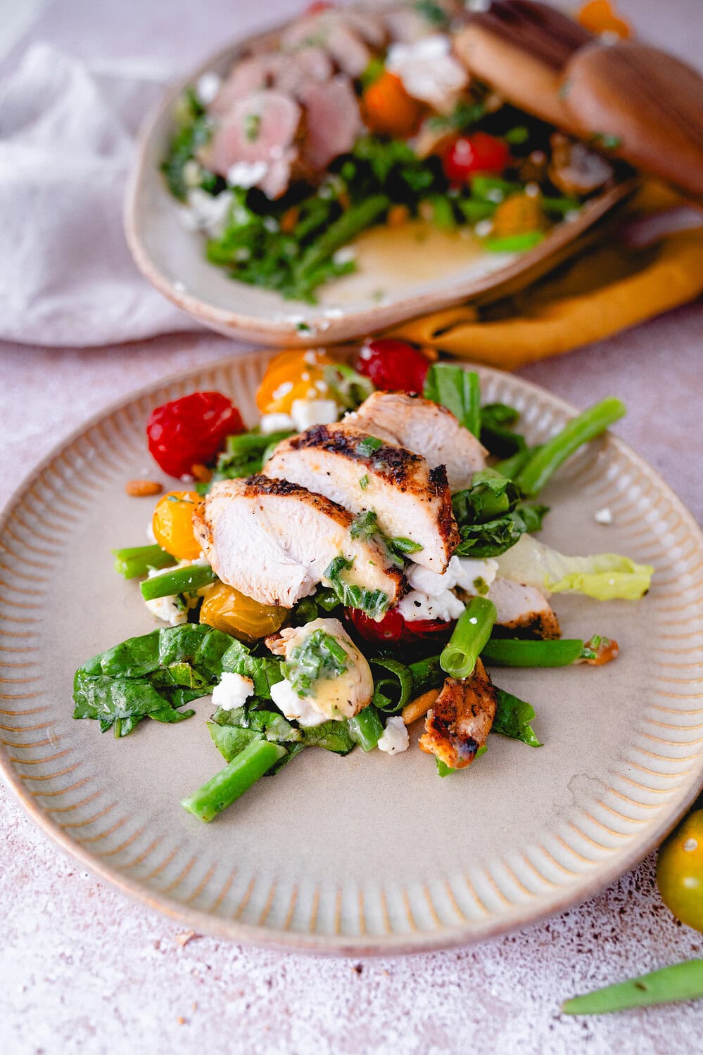 Auf einem Teller liegt eine Portion des griechischen Grillplatte, grüner Salat, bunte Tomaten, Hähnchenbrust