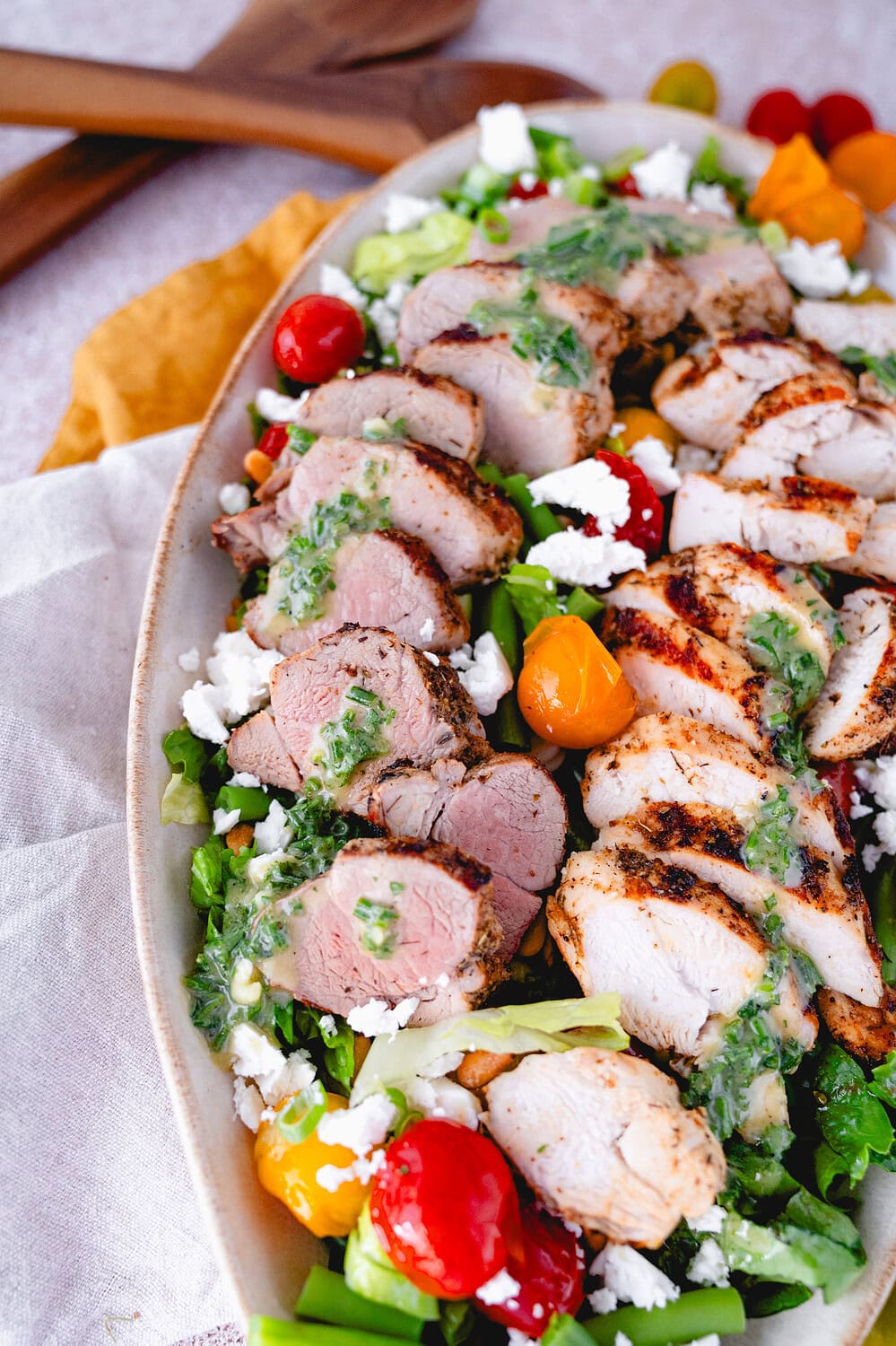 Griechischer Grillteller auf einem grünen Salat auf einer Salatplatte. Gegrilltes Schweinefilet mit gegrillter Hähnchenbrust