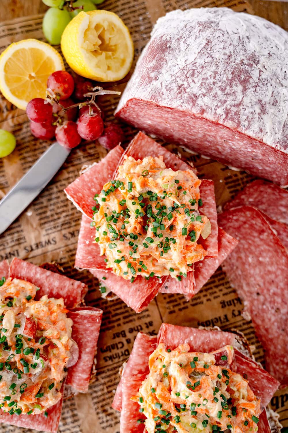 Smörrebröd with Aoste Le Briedu salami and a topping of carrots, apples and chives and a loaf of salami