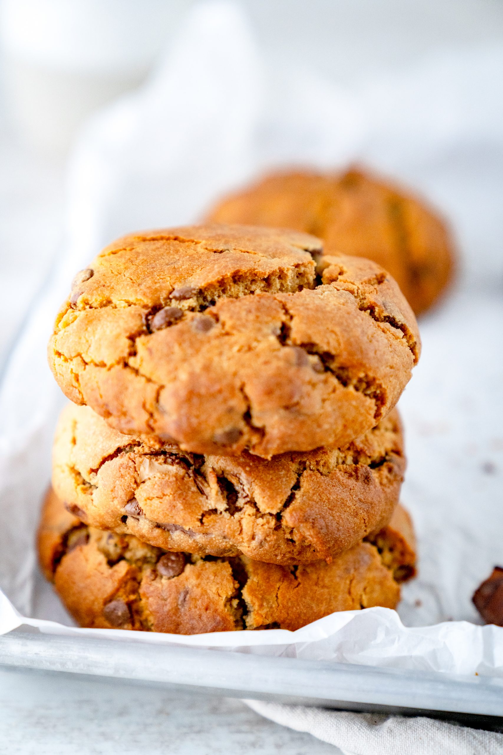 Drei gestapelte Nutella Cookies aus der Heißluftfritteuse auf einem Backblech mit weißem Backpapier