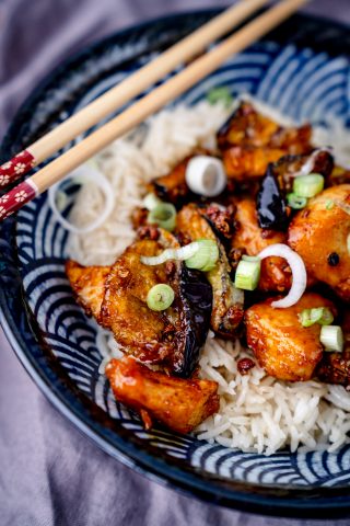 Foto von Asiatisch frittierter Auberginen mit Hähnchenfleisch und Reis in einer blauen Schale mit Essstäbchen