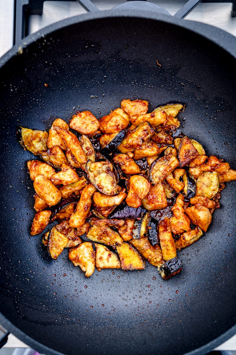 Frittierte Auberginen mit Hähnchen im Wok