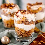 Geschichtetes Bratapfel-Tiramisu in Gläsern auf einem Holzbrett