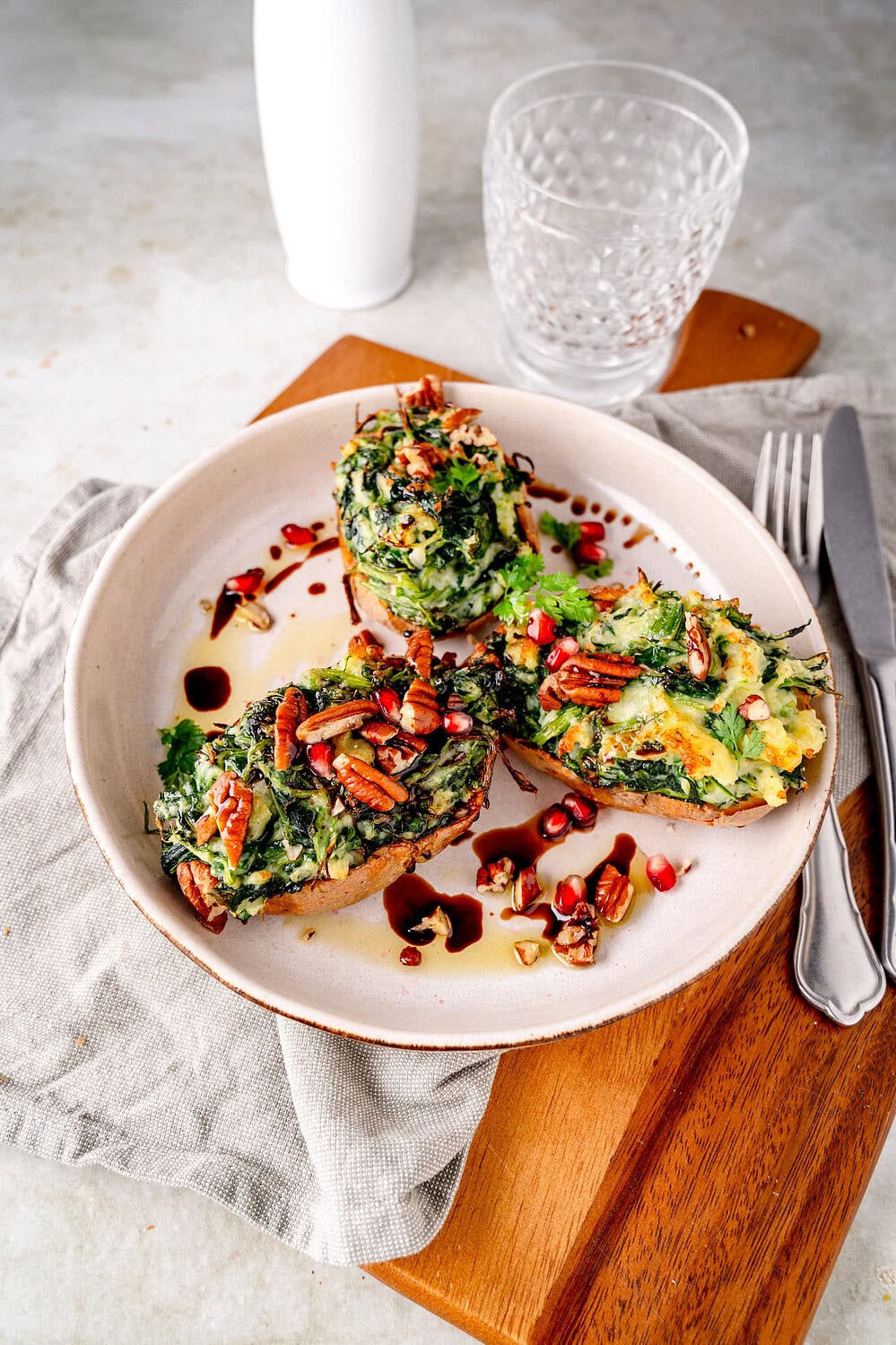 Gefüllte Ofenkartoffel mit Spinat, Käse und Pekannüssen.