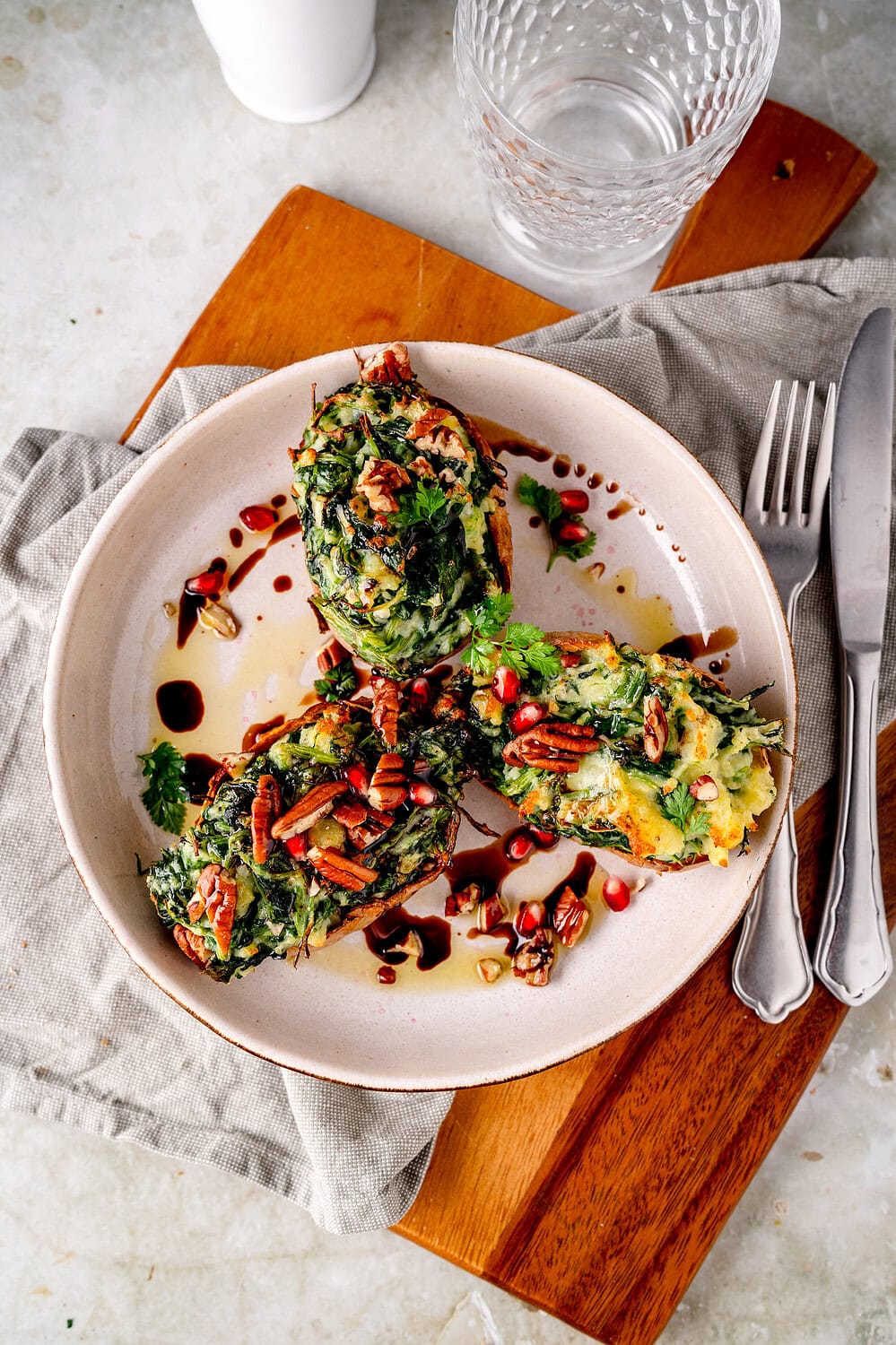 Mit Spinat und Gorgonzola gefüllte Ofenkartoffeln auf einem Teller.