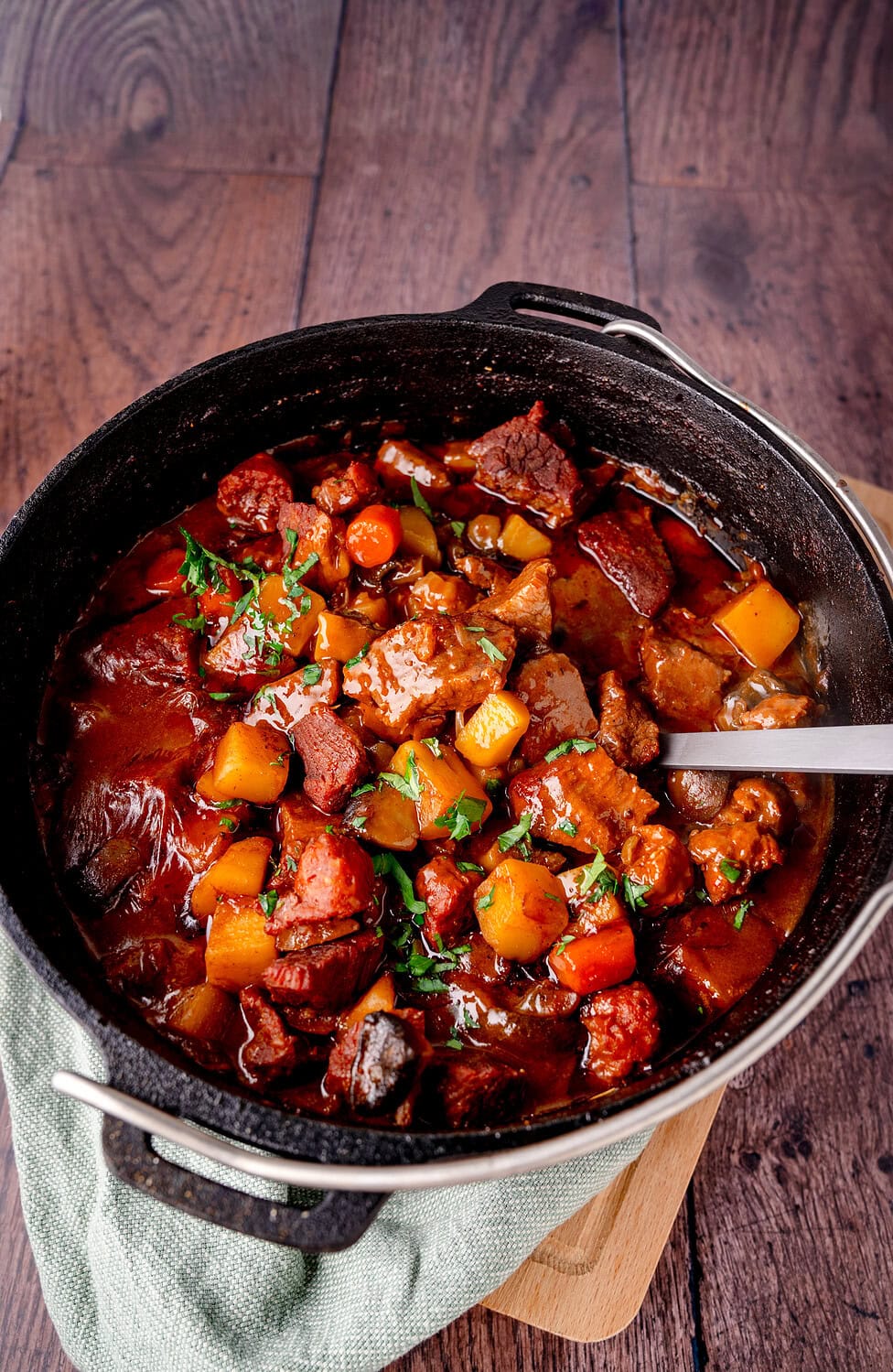 Deftiges Rindergulasch mit Karotten und Kartoffeln in einem Schmortopf.