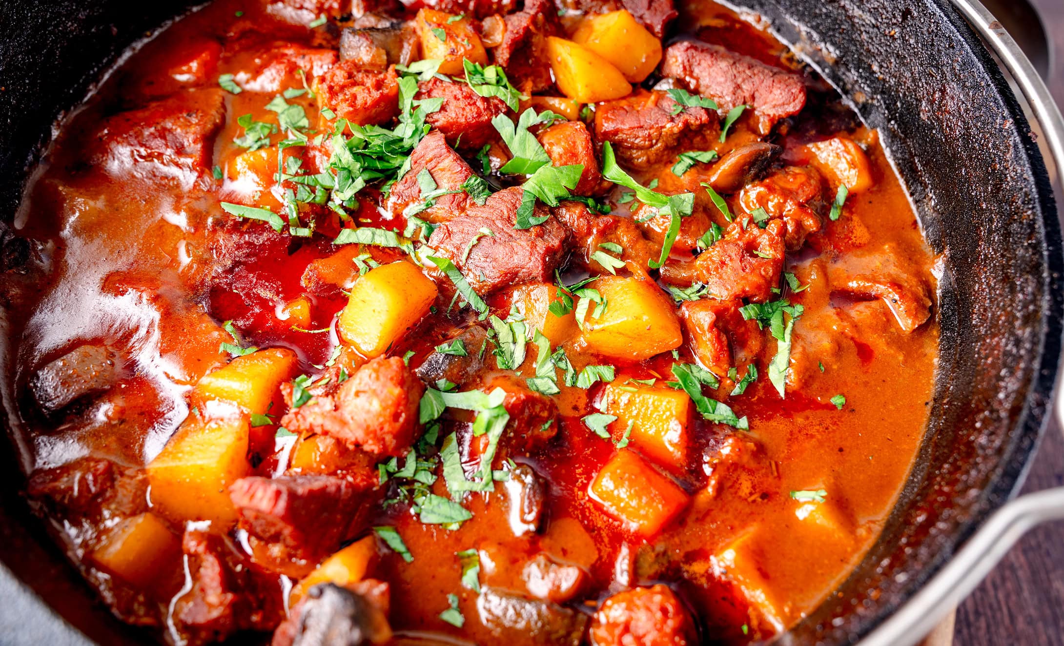 Herzhaftes Rindergulasch mit Kartoffeln und Karotten in einer Tomatensauce.