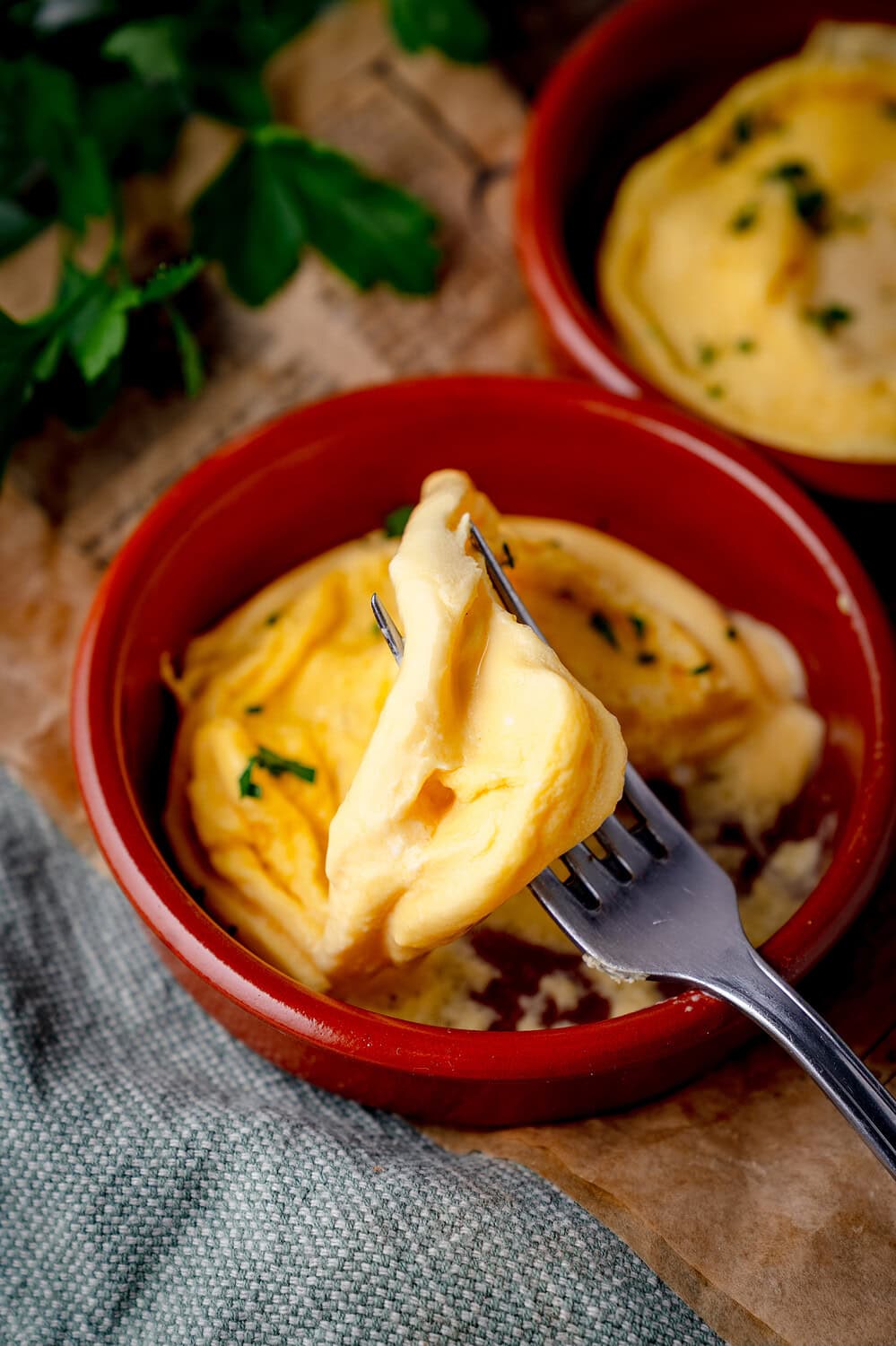 Cremiges Eieromelett in einer roten Schale mit frischer Petersilie.