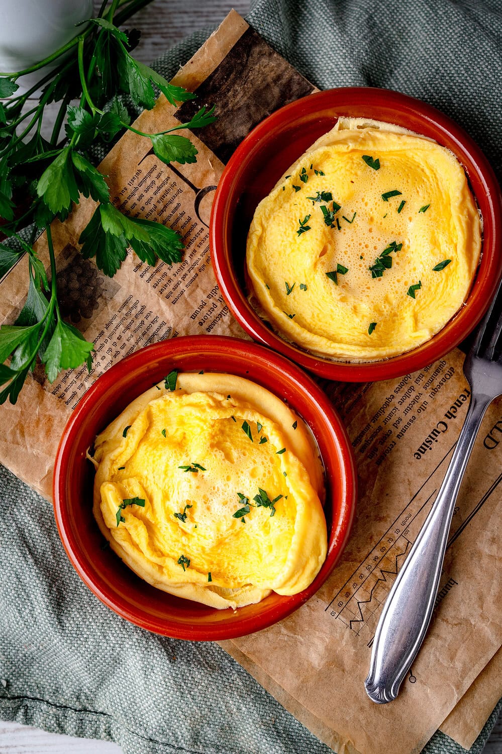 Zwei Omeletts im kleinen Schälchen mit frischer Petersilie, warm serviert.