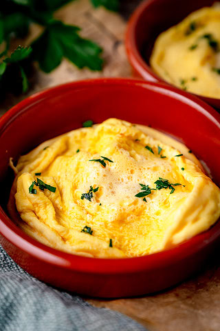 Saftiges Omelett mit frischer Petersilie in einer roten Form.