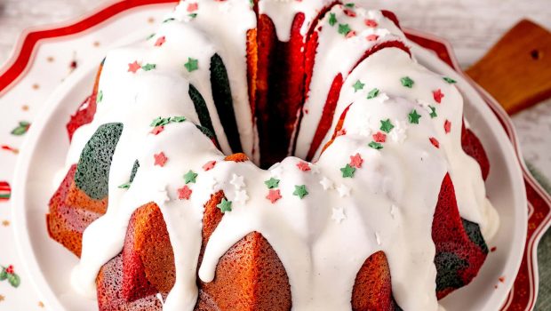 Weihnachtlicher Marmorkuchen in rot und grün mit weißem Zuckerguss auf einem Weihnachtsteller mit Weihnachtsdekoration