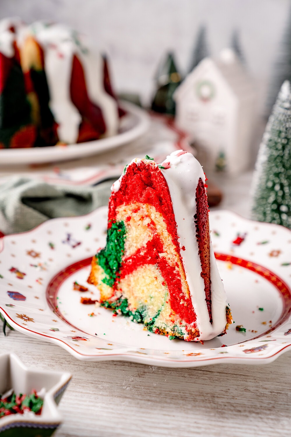 Bunt geschichteter Weihnachtskuchen mit Zuckerguss und Dekorationen.