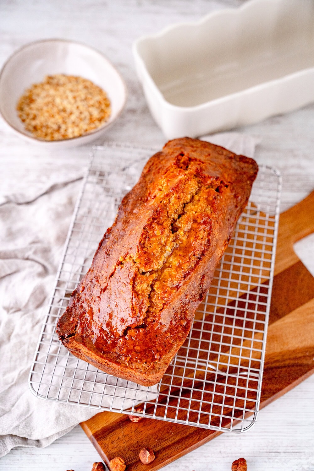 Saftiger Nusskuchen mit Aprikosenglasur auf Abkühlgitter mit Haselnüssen