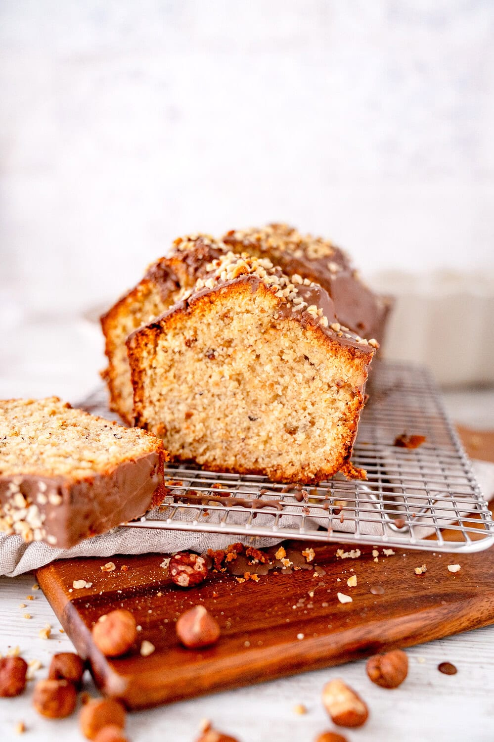Nusskuchen nach Mama, angeschnitten, auf Holzbrett mit Schokoglasur
