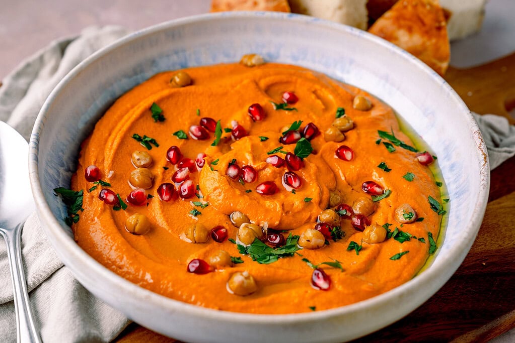 Leckeres Rezept: gerösteter Paprika Hummus mit Granatapfel, ideal zum Dippen oder als Beilage.