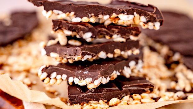 Nahaufnahme von Schokoladen Puffreis aus der Heißluftfritteuse, auf Holzbrett, weißem Tuch.