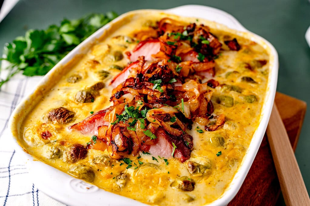 Kasseler nach Landfrauenart mit Rosenkohl und Schmorzwiebeln im Ofen in einer Auflaufform überbacken