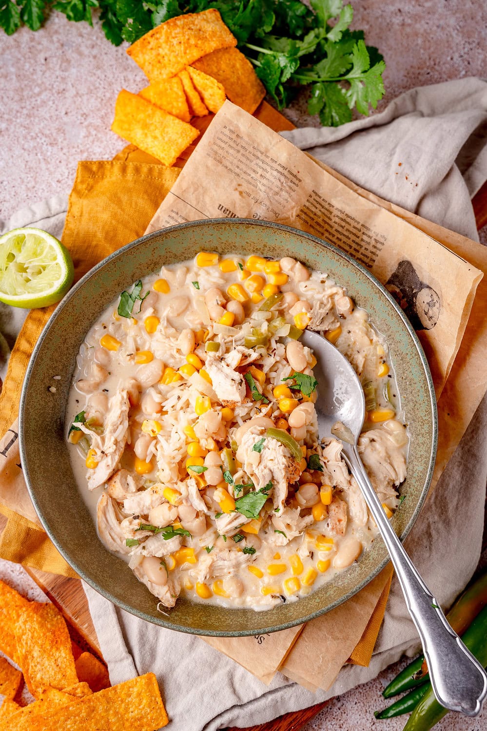 A portion of white chicken chili served in a plate with coriander