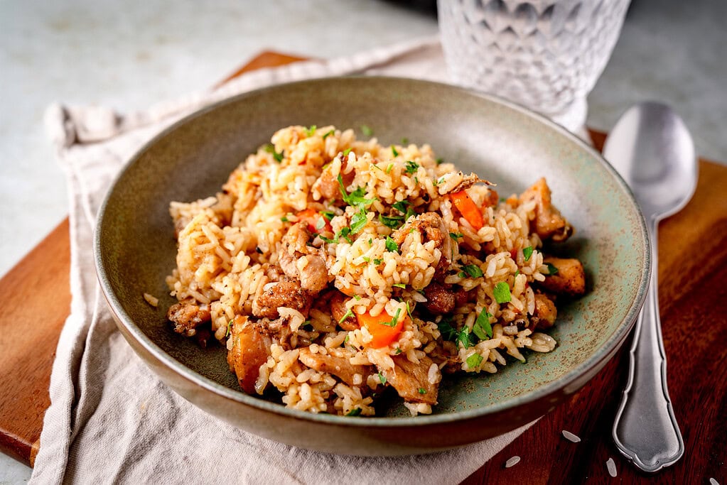 Plov mit Pollo Fino und Möhren auf einem Teller serviert
