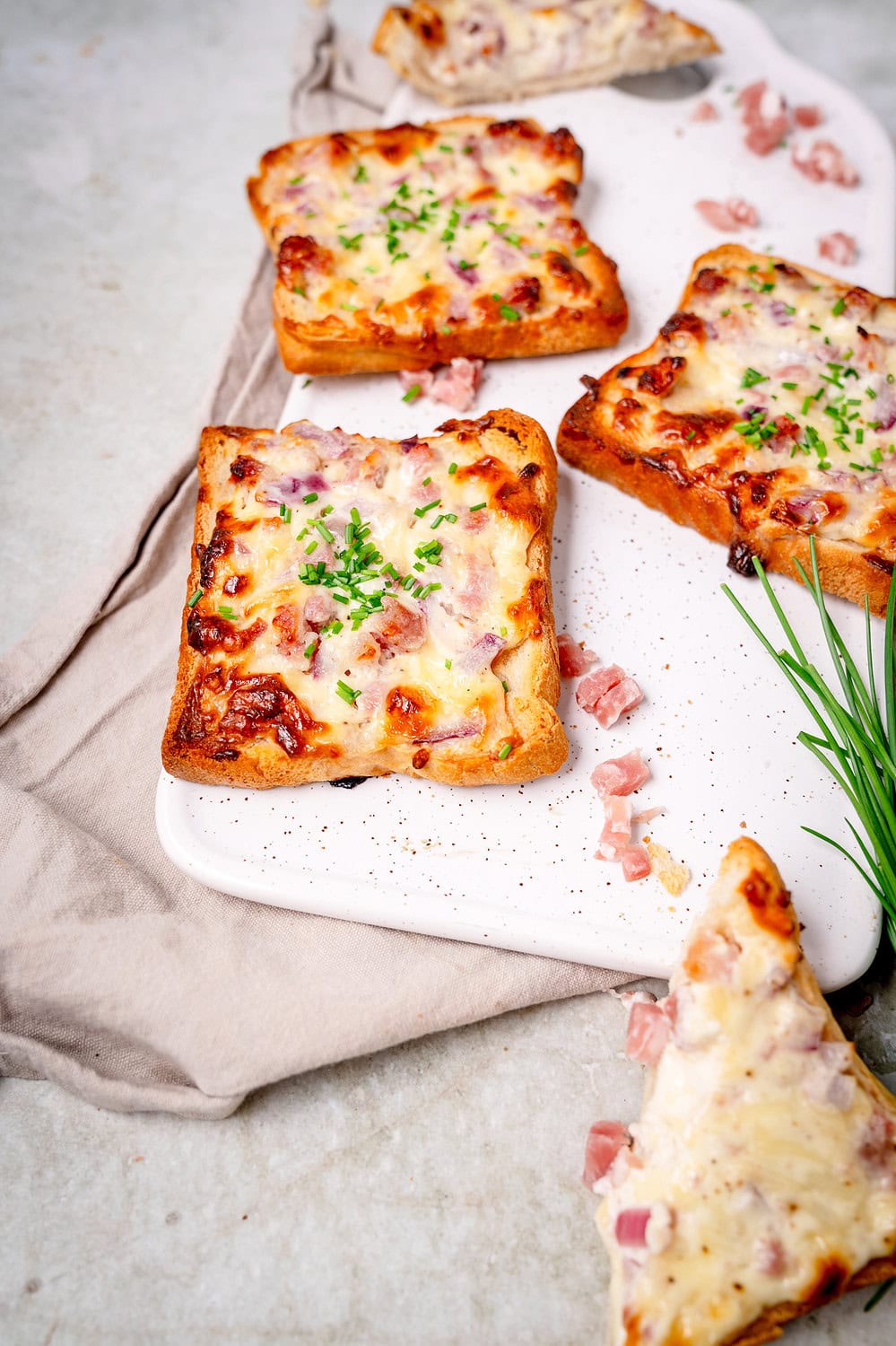 Simple tarte flambée toast with bacon, onions and chives.