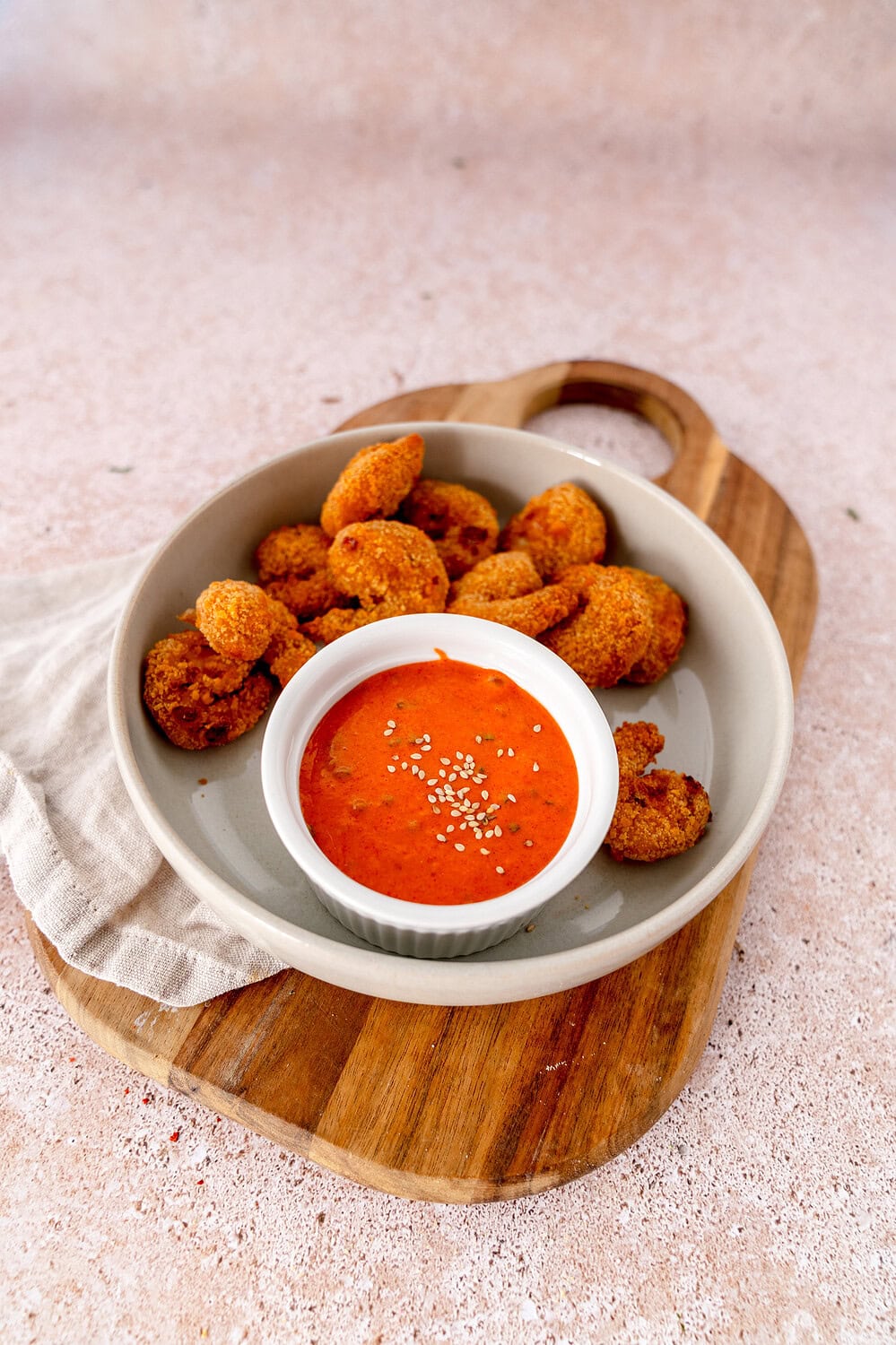 A small bowl of Gochujang Mayo on a plate full of crispy shrimp