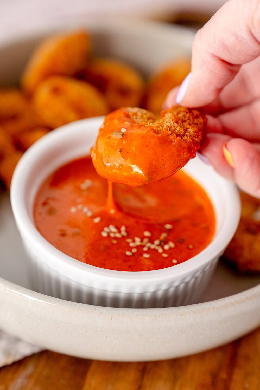 Breaded shrimp was dipped into a small bowl full of gochujang mayo