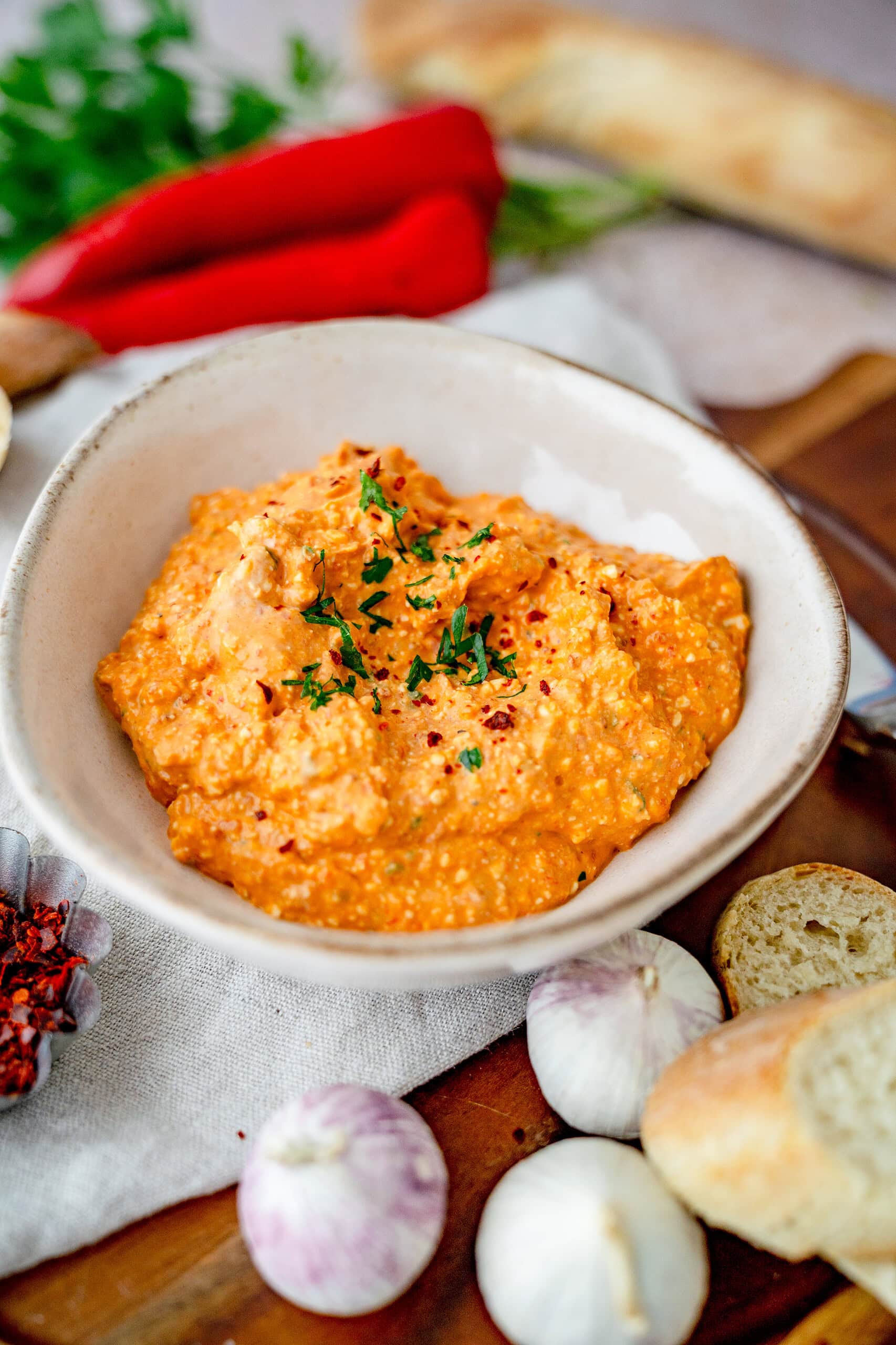 Scharfer Grieche, paprikadip in einer Schüssel mit kleingehackter Petersilie obendrauf.