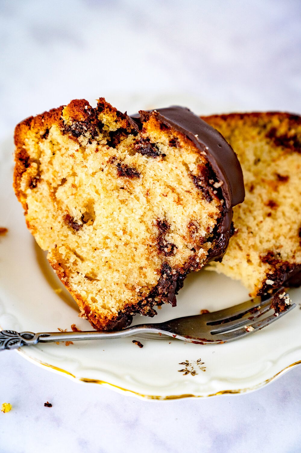 Sliced ​​chocolate chip cookie Gugelhupf on a cake plate with a fork