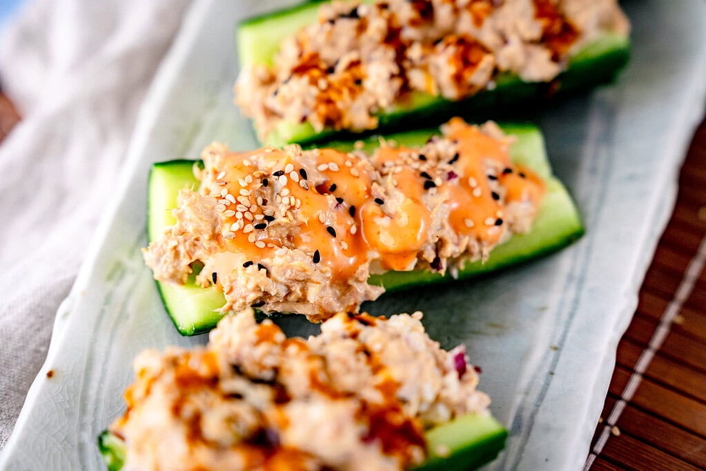 Tuna and cucumber boats in landscape format. Stuffed cucumber with tuna mayo and Sriracha mayo, sprinkled with sesame 