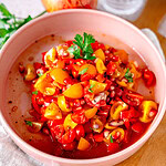 Tomaten-Granatapfel-Salat in einer weißen Schale.