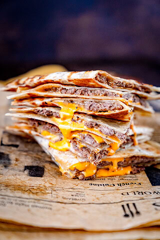 Leckere Cheeseburger Quesadillas auf einem Zeitungsblatt