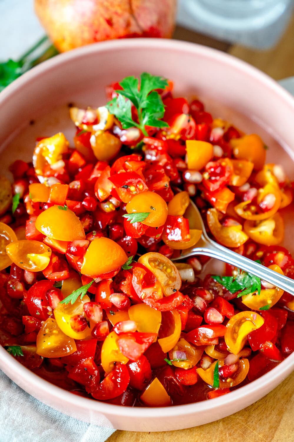 Eine Nahaufnahme vom Tomaten-Granatapfel-Salat mit Petersilie