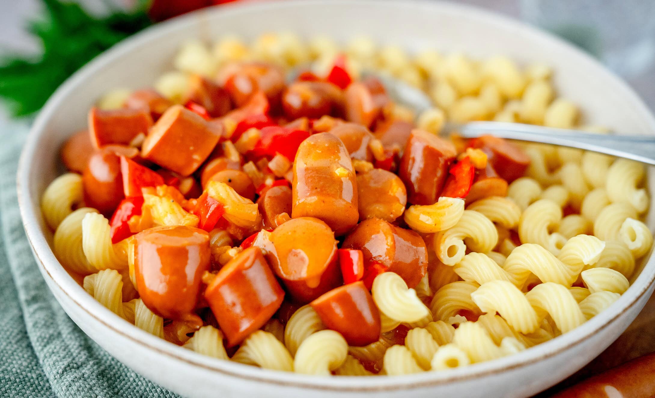 Würstchengulasch mit Nudeln in einem tiefen Teller