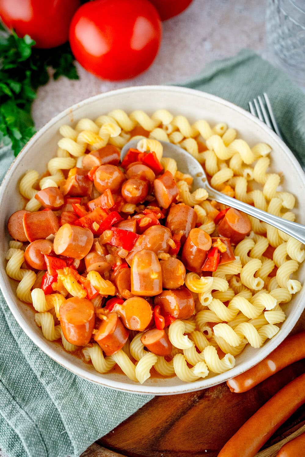 Würstchengulasch mit Nudeln in einem tiefen Teller.