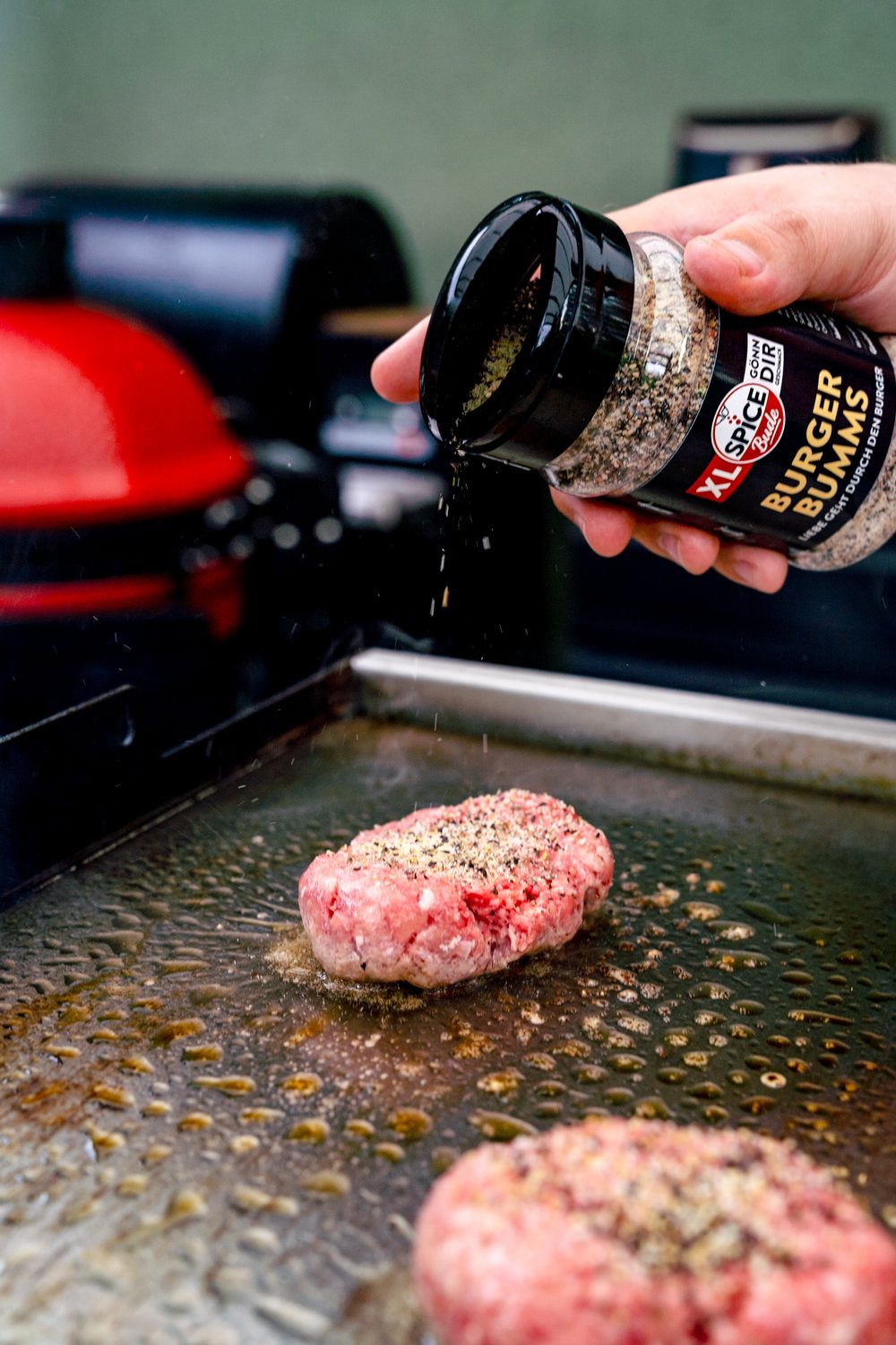 Rindfleischpatty wird gewürzt mit Burger Bumms
