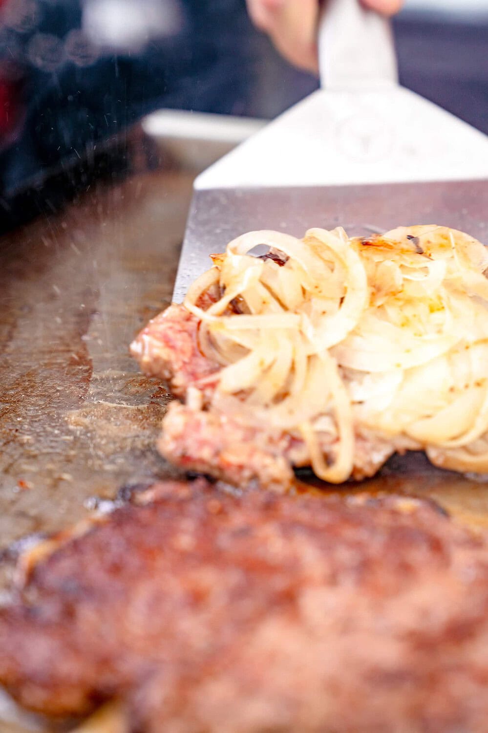 Der Oklahoma Fried Onion Burger wird gewendet