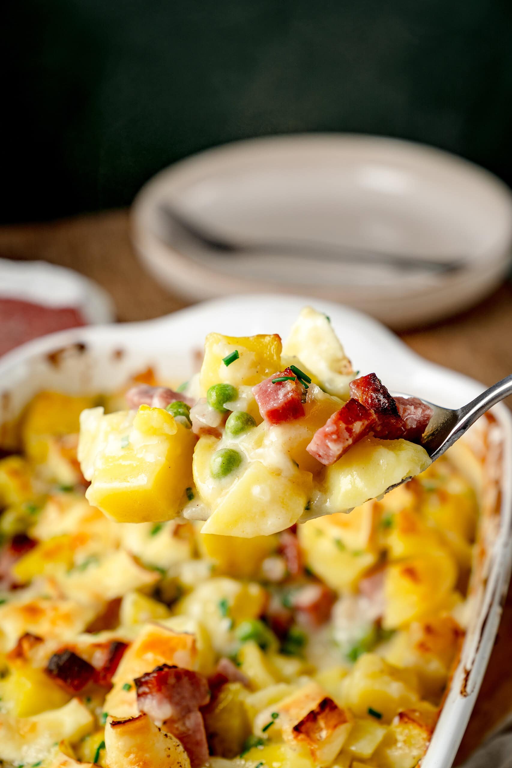 Ein leckerer Löffel mit Kartoffelauflauf und Salami