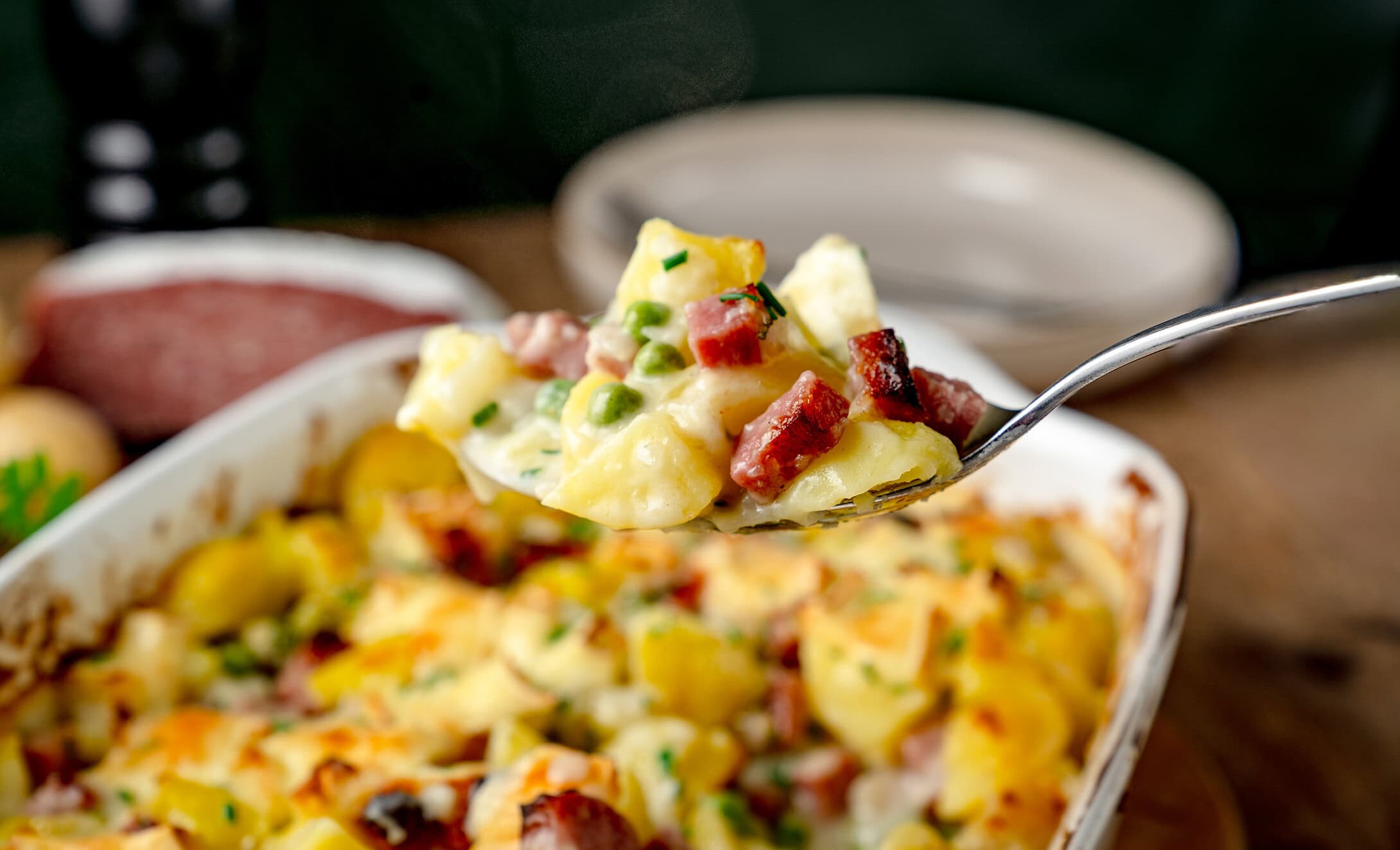 Kartoffelauflauf mit Salami in der Queransicht auf einem Löffel