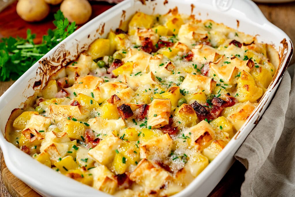 Auflaufform, frisch aus dem Ofen, mit Kartoffelauflauf und Salami