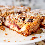 Kirsch-Streuselkuchen mit Hafer auf Kuchenständer