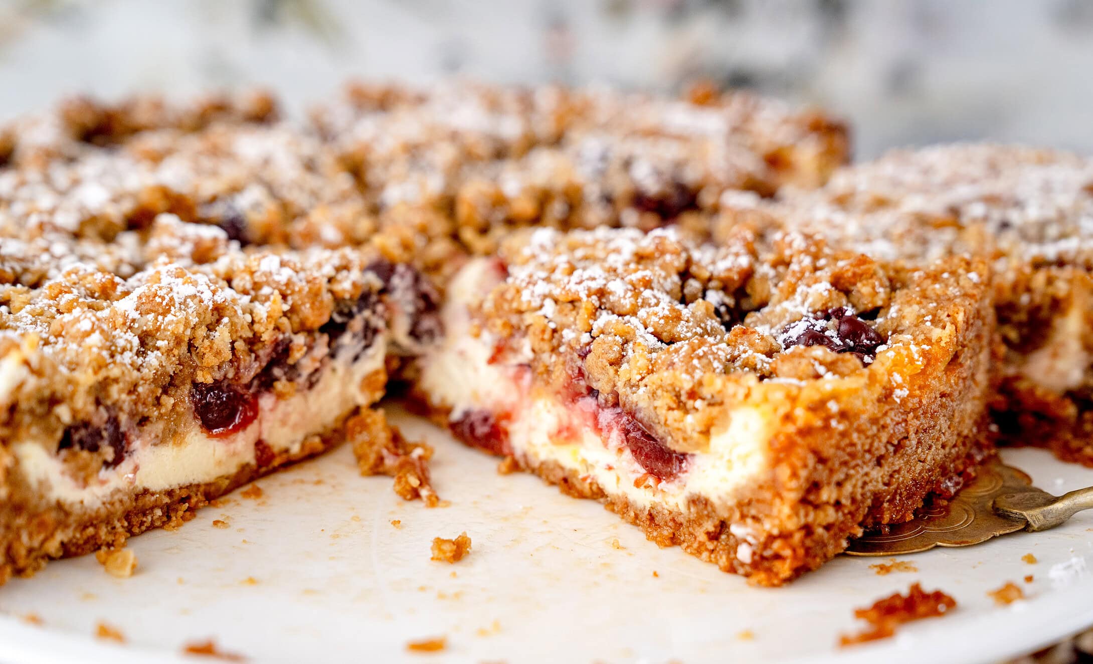 Kirsch-Streuselkuchen mit Hafer auf Kuchenständer